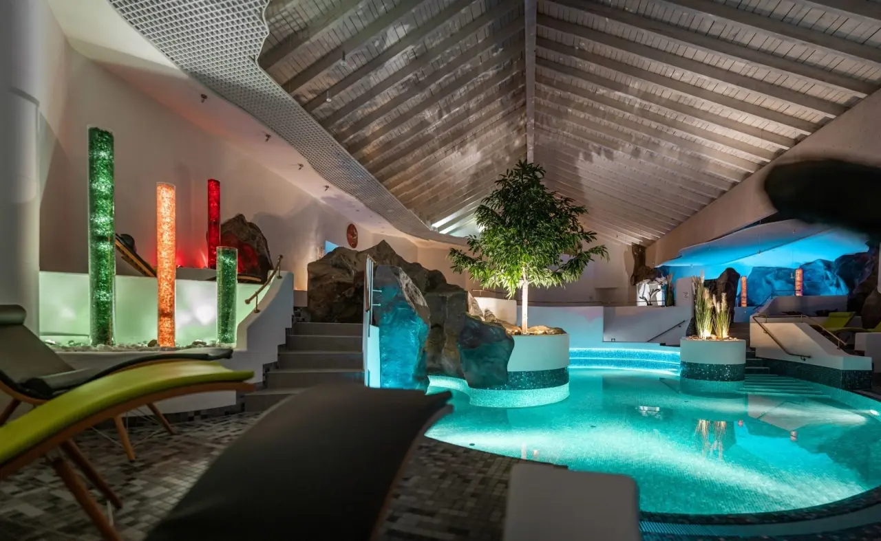 Einladender Innenpool mit stimmungsvoller Beleuchtung und Entspannungsbereich im Hotel Wutzschleife.