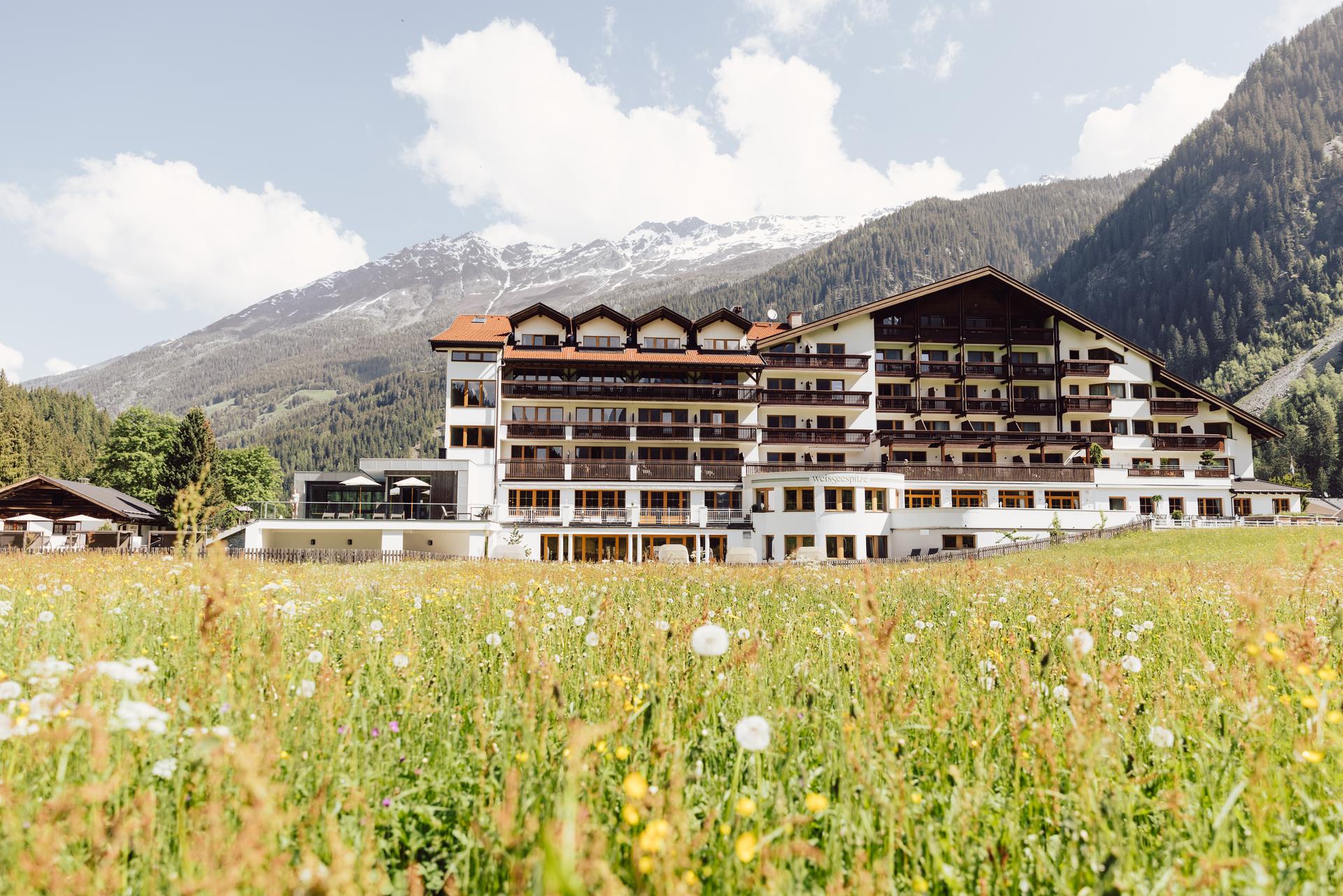 Hotel Weisseespitze in Kaunertal – Hotelgebäude umgeben von Bergwiesen und Alpenpanorama | Wellnesshotel Tirol