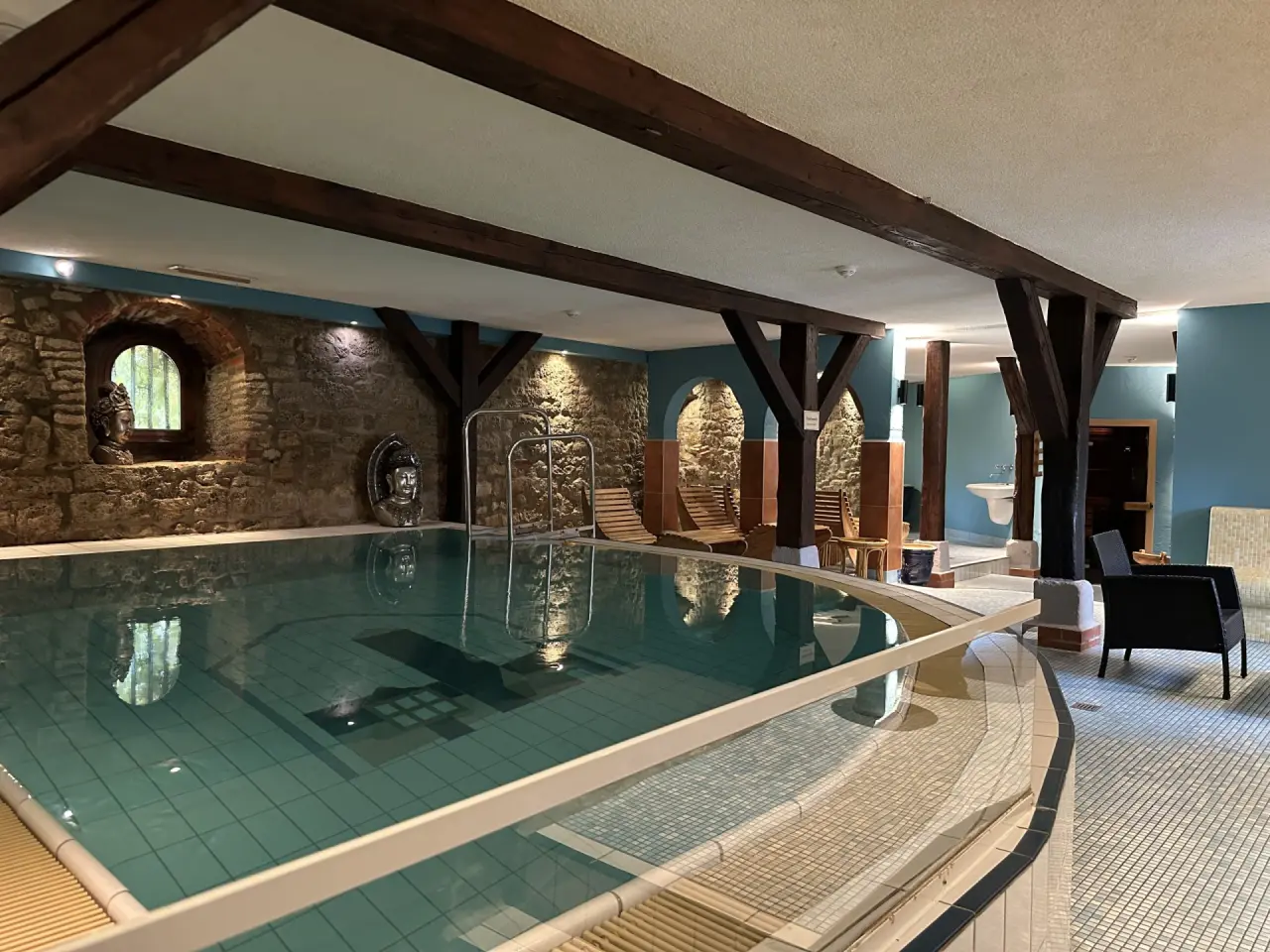 Innenpool mit rustikalen Holzbalken und Steinwänden im Spa-Bereich des Hotel & Spa Wasserschloss Westerburg.