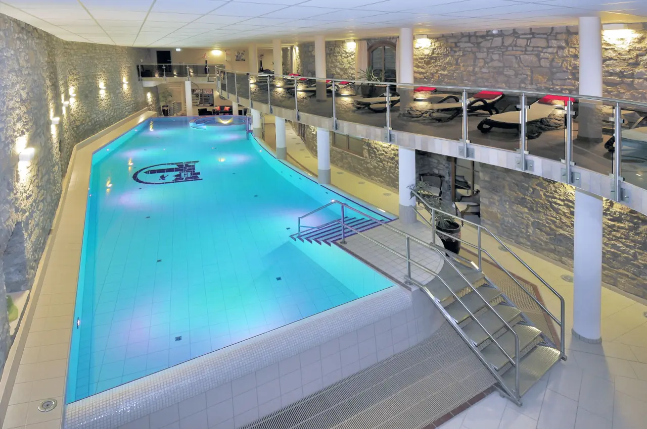 Großzügiger Innenpool mit Whirlpool und Liegebereich im Hotel & Spa Wasserschloss Westerburg. Ideal für Entspannung.