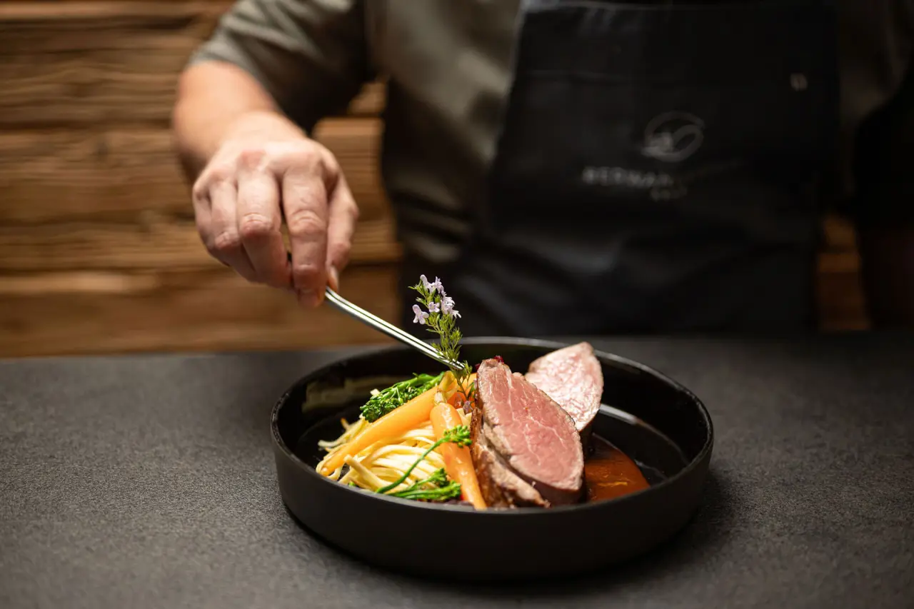 Chef garniert ein kunstvoll angerichtetes Gericht im Restaurant des Hotel Berwanger Hof.