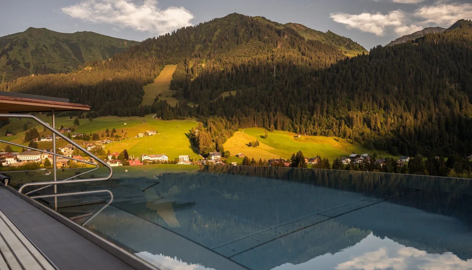 Hotel Erlebach in Riezlern – Infinity-Pool mit Panoramablick auf die Berge am Tag | Wellnesshotel Vorarlberg