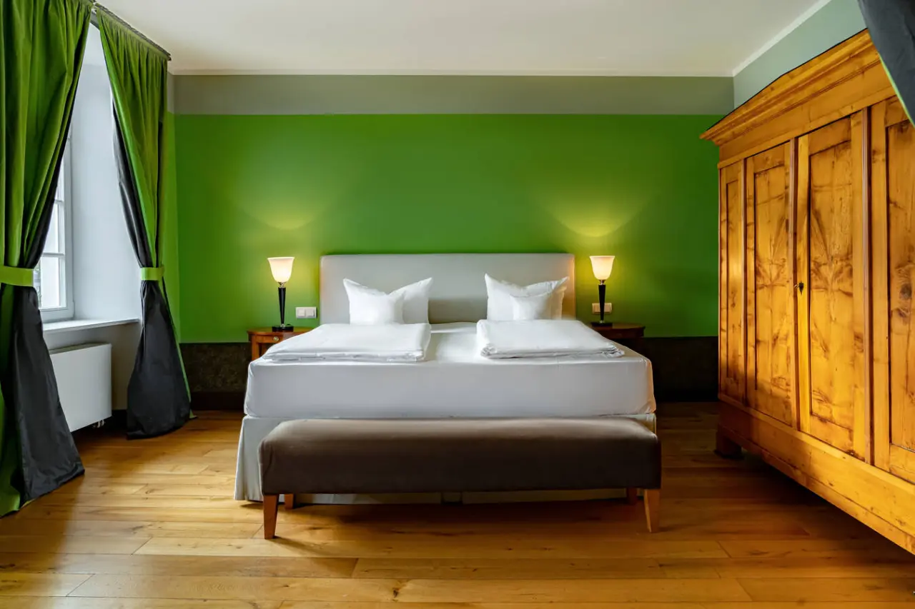 Jugendstil-Doppelzimmer mit grünem Akzent und Holzboden im Romantik Jugendstilhotel Bellevue.