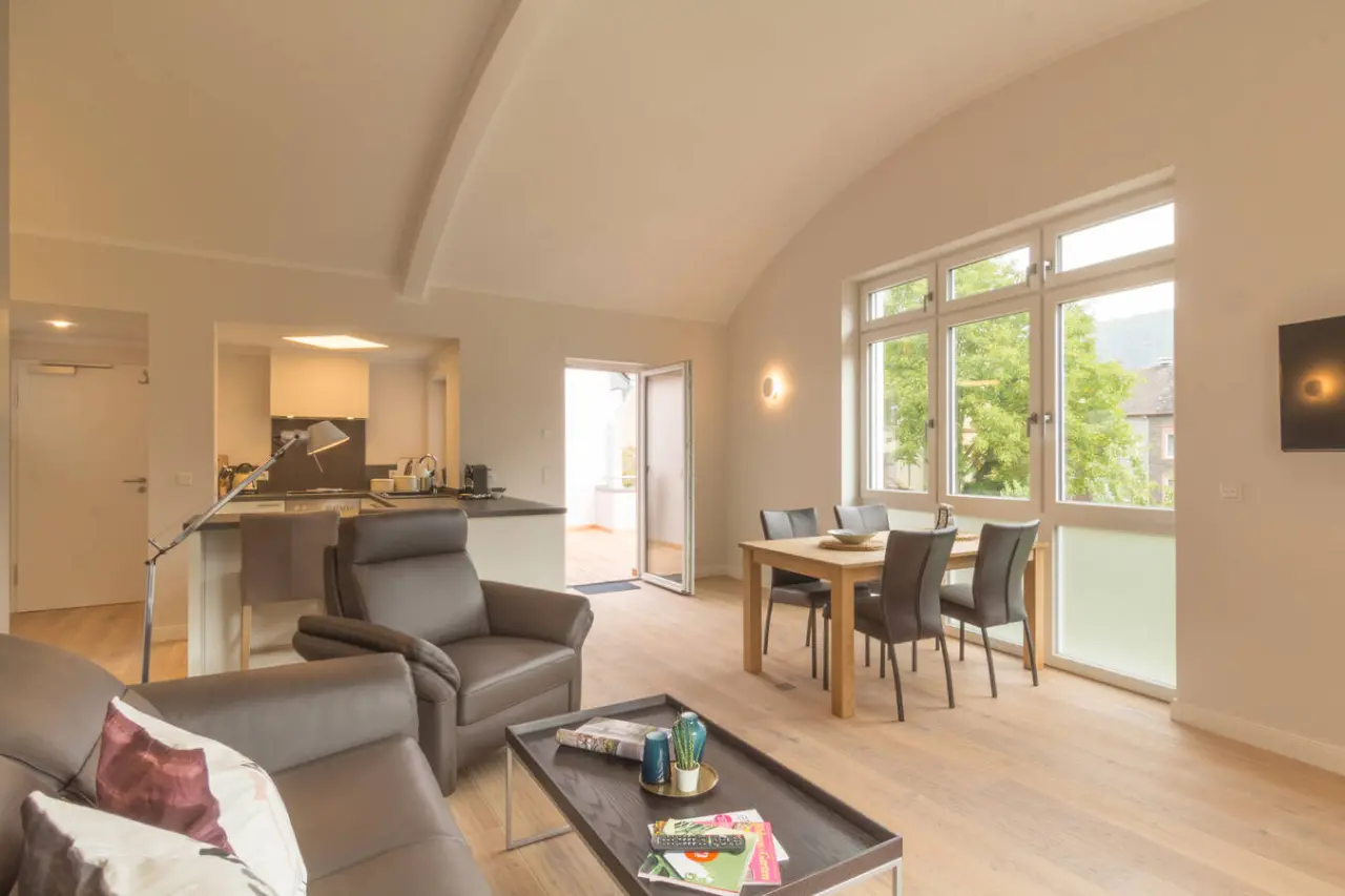 Geräumiges Wohn- und Esszimmer mit integrierter Küchenzeile und großen Fenstern im Romantik Jugendstilhotel Bellevue.