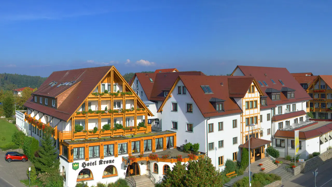 Aussenansicht des Ringhotel Krone Schnetzenhausen mit traditioneller Architektur und grüner Umgebung unter blauem Himmel.