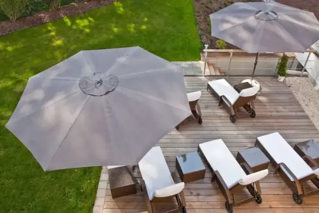 Sonnenterrasse mit Liegestühlen und Sonnenschirmen im Gartenbereich des Vitalhotel Sonneck für entspannte Stunden.