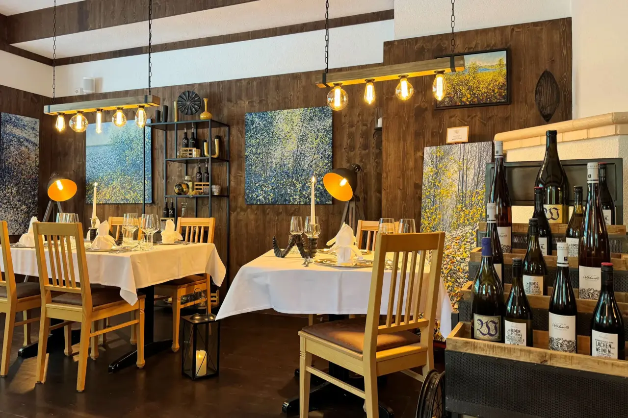 Gemütliches Restaurant im Vitalhotel Sonneck mit elegant gedeckten Tischen, Holzwänden und moderner Kunst.