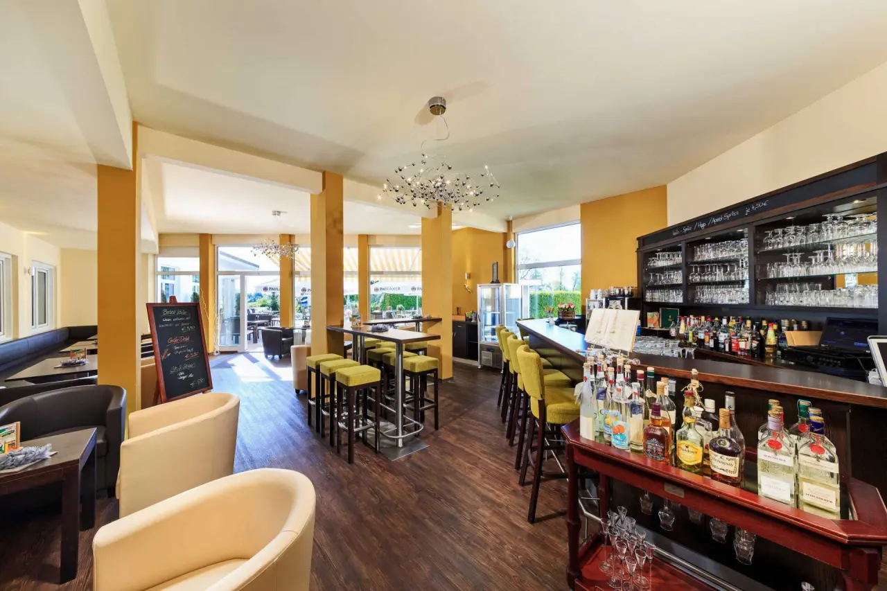 Gemütliche Hotelbar mit Barhockern, Lounge-Sesseln und Getränkeauswahl im Vitalhotel Sonneck.