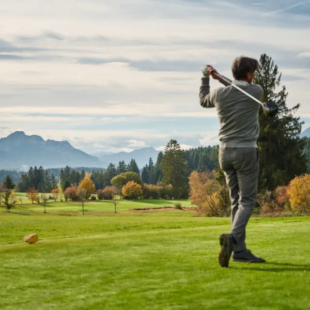 Golfer auf dem malerischen Golfplatz des Hotel Auf der Gsteig mit herbstlicher Bergkulisse und Alpenpanorama.