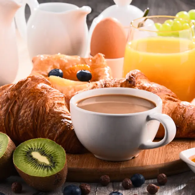 Reichhaltiges Frühstück mit Croissants, Kaffee, Saft und frischem Obst im Hotel Auf der Gsteig.