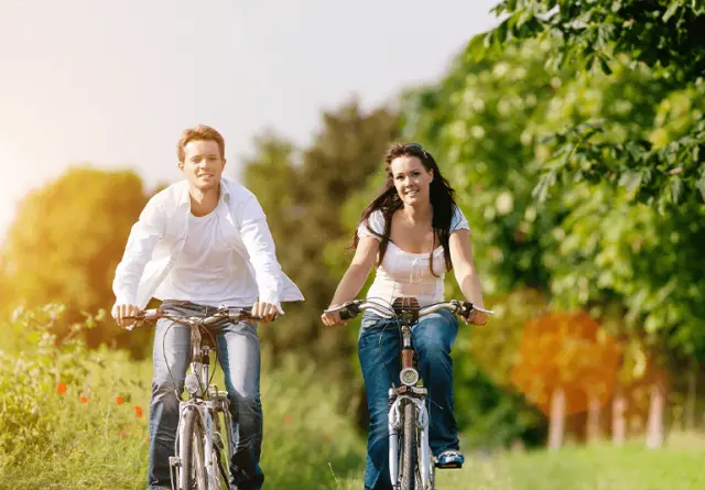 Paar beim Fahrradfahren in grüner Landschaft nahe dem Kurhotel Hochsauerland 2010. Aktive Erholung und Naturerlebnisse.