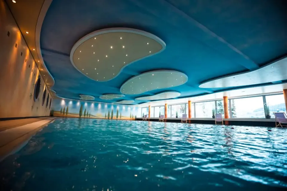 Großer, beleuchteter Innenpool mit Panoramafenstern und Liegestühlen im Kurhotel Hochsauerland 2010.