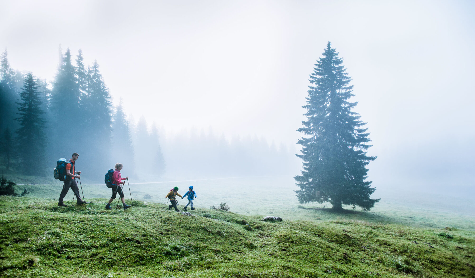 Bergresort Seefeld in Seefeld – Familie beim Wandern in nebliger Berglandschaft | Wellnesshotel Tyrol