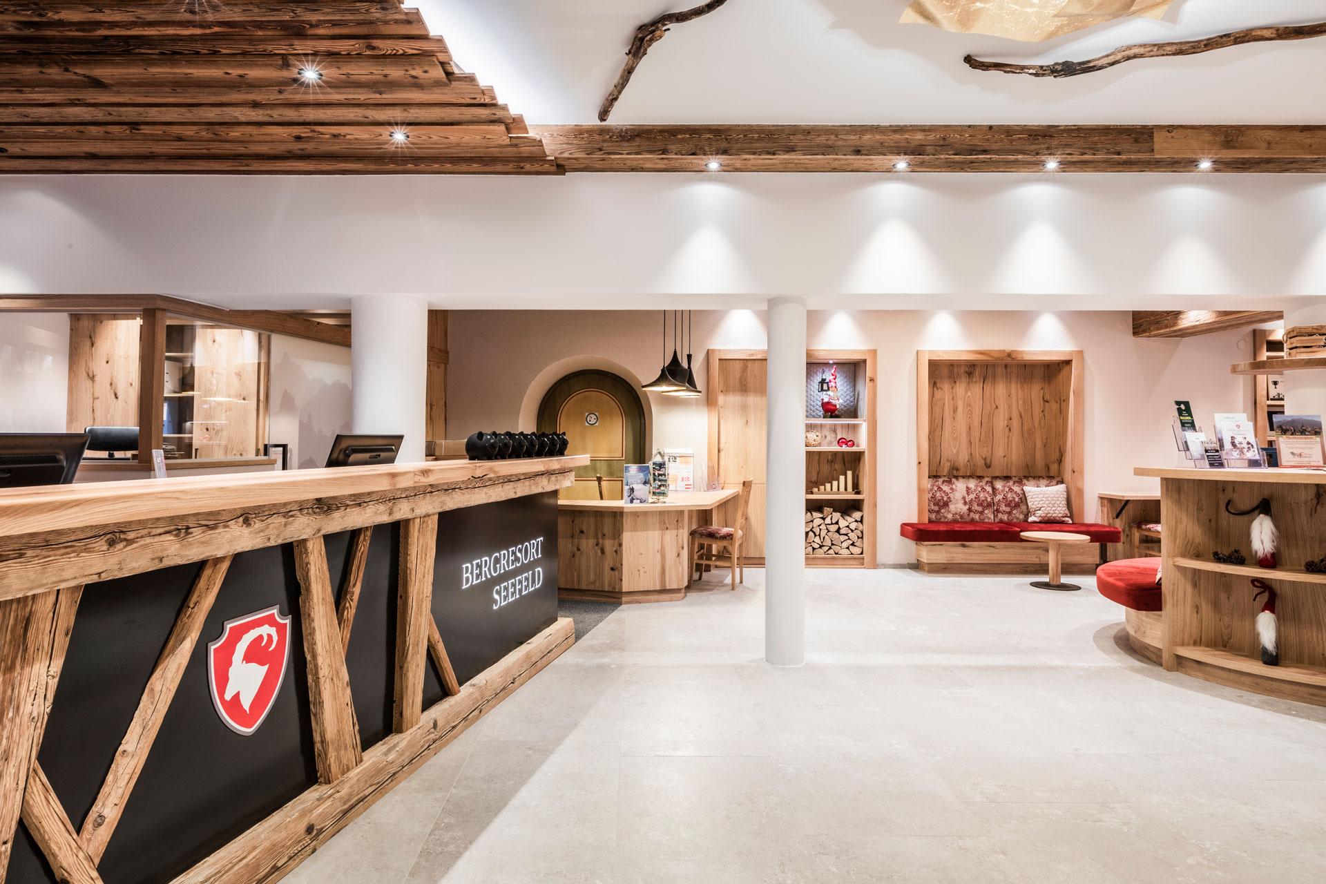 Bergresort Seefeld in Seefeld – Gemütliche Lounge mit rotem Sitzbereich und Rundfenster | Wellnesshotel Tirol