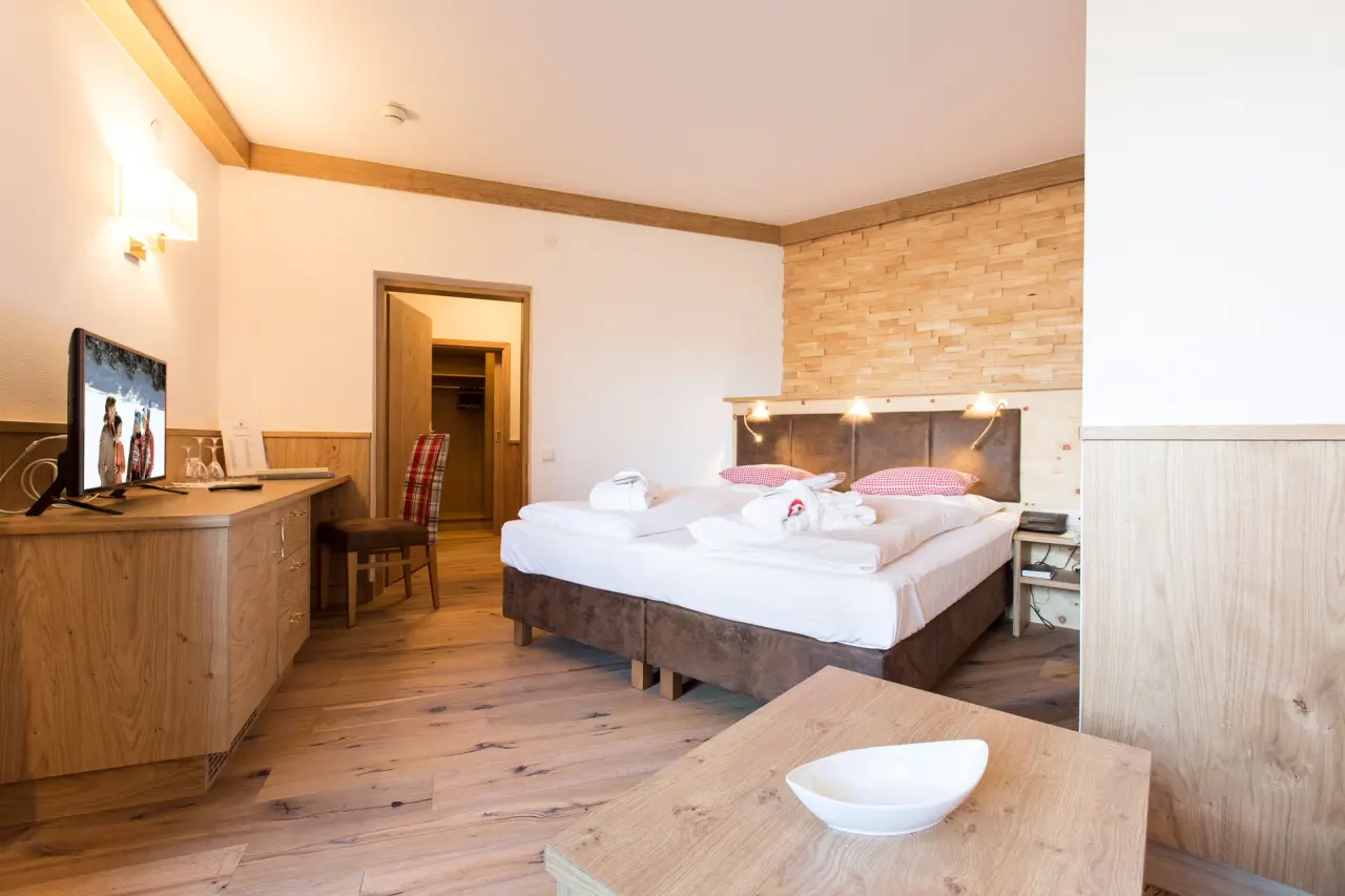Gemütliches Doppelzimmer im alpinen Stil mit Holzelementen und Bademänteln im Bergresort Seefeld.
