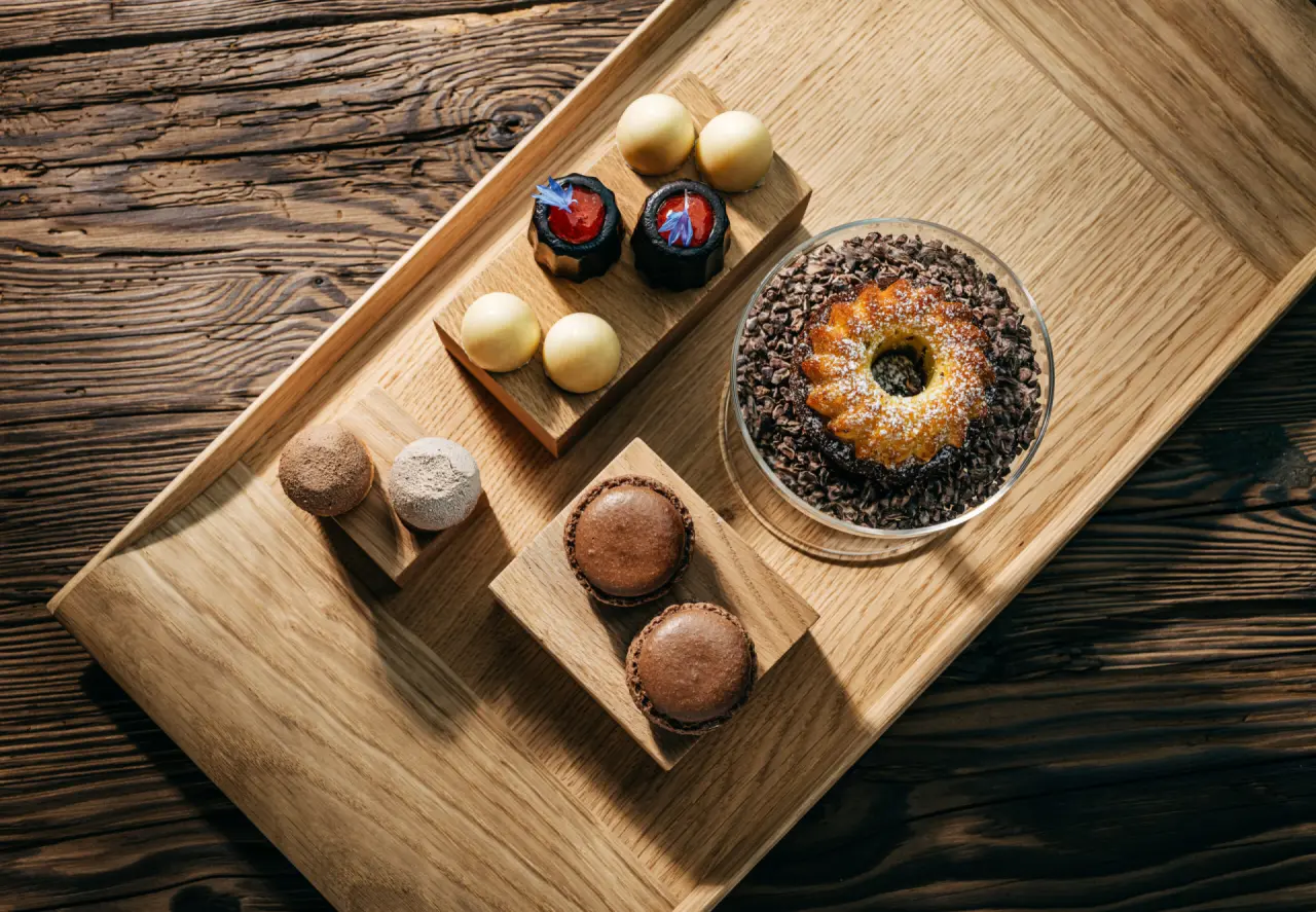 Ansprechende Auswahl an Desserts und Gebäck auf einem Holztablett im Luisenhöhe Gesundheitsresort Schwarzwald.