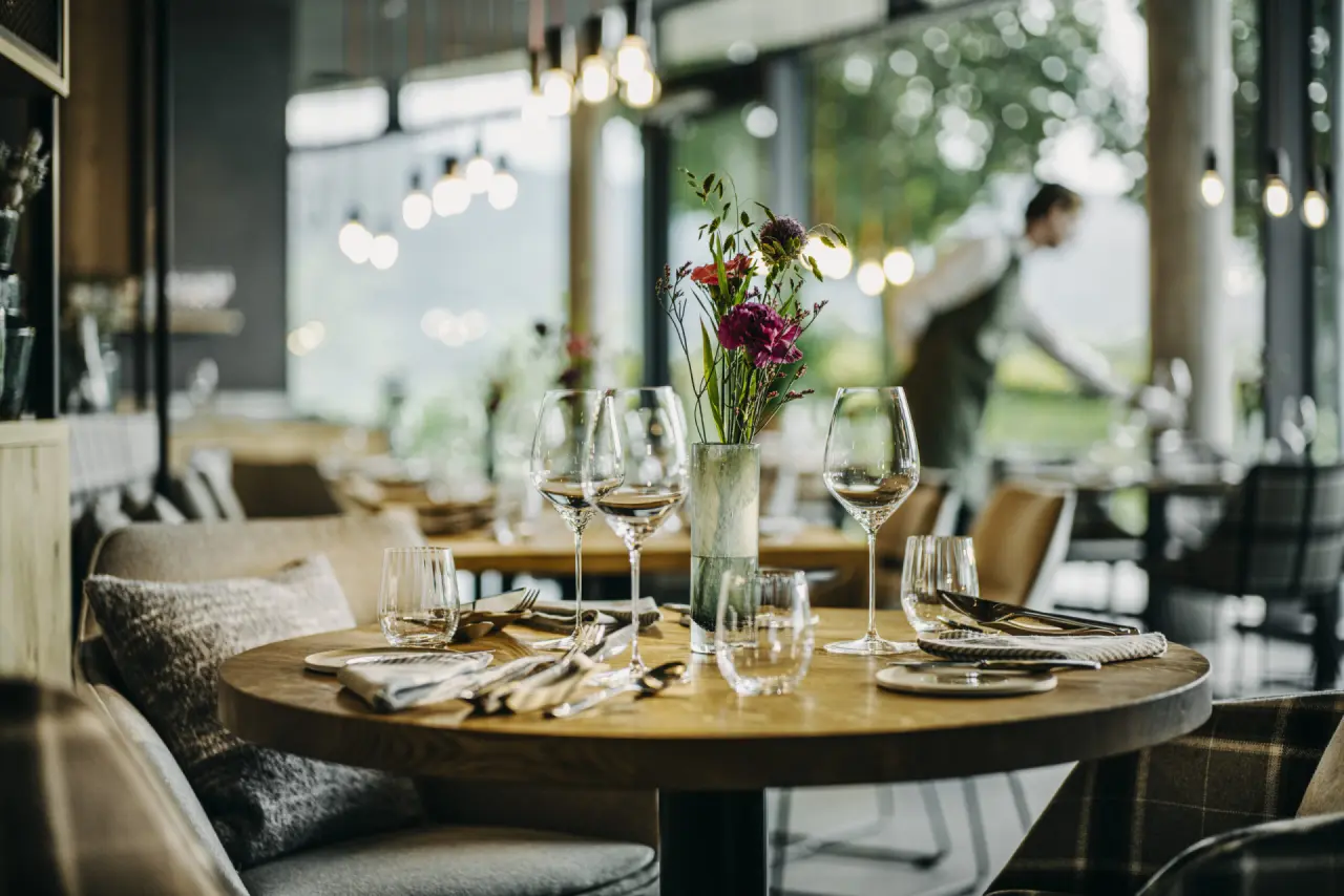 Elegant gedeckter Tisch im Restaurant des Luisenhöhe Gesundheitsresort Schwarzwald mit Blick ins Grüne.