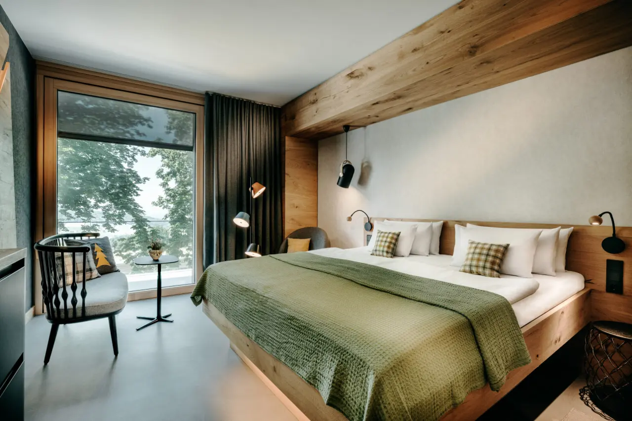 Modernes Hotelzimmer mit Doppelbett, Holzelementen und Panoramablick im Gesundheitsresort Luisenhöhe Schwarzwald.