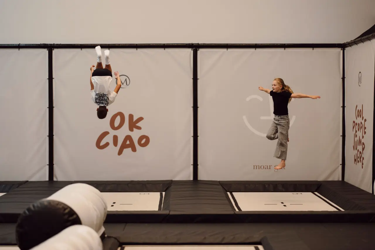 Kinder springen und turnen ausgelassen im modernen Trampolinpark des Familien Natur Resort Moar Gut.