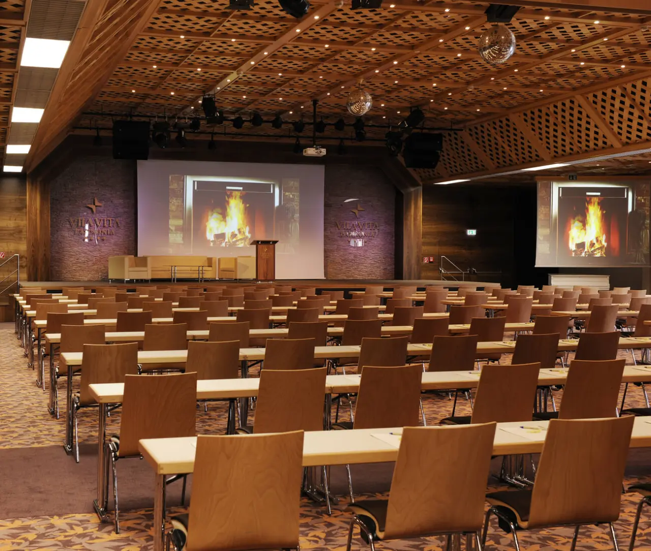 Großer Konferenzraum im VILA VITA Pannonia mit Reihenbestuhlung, Bühne und Projektionsflächen.