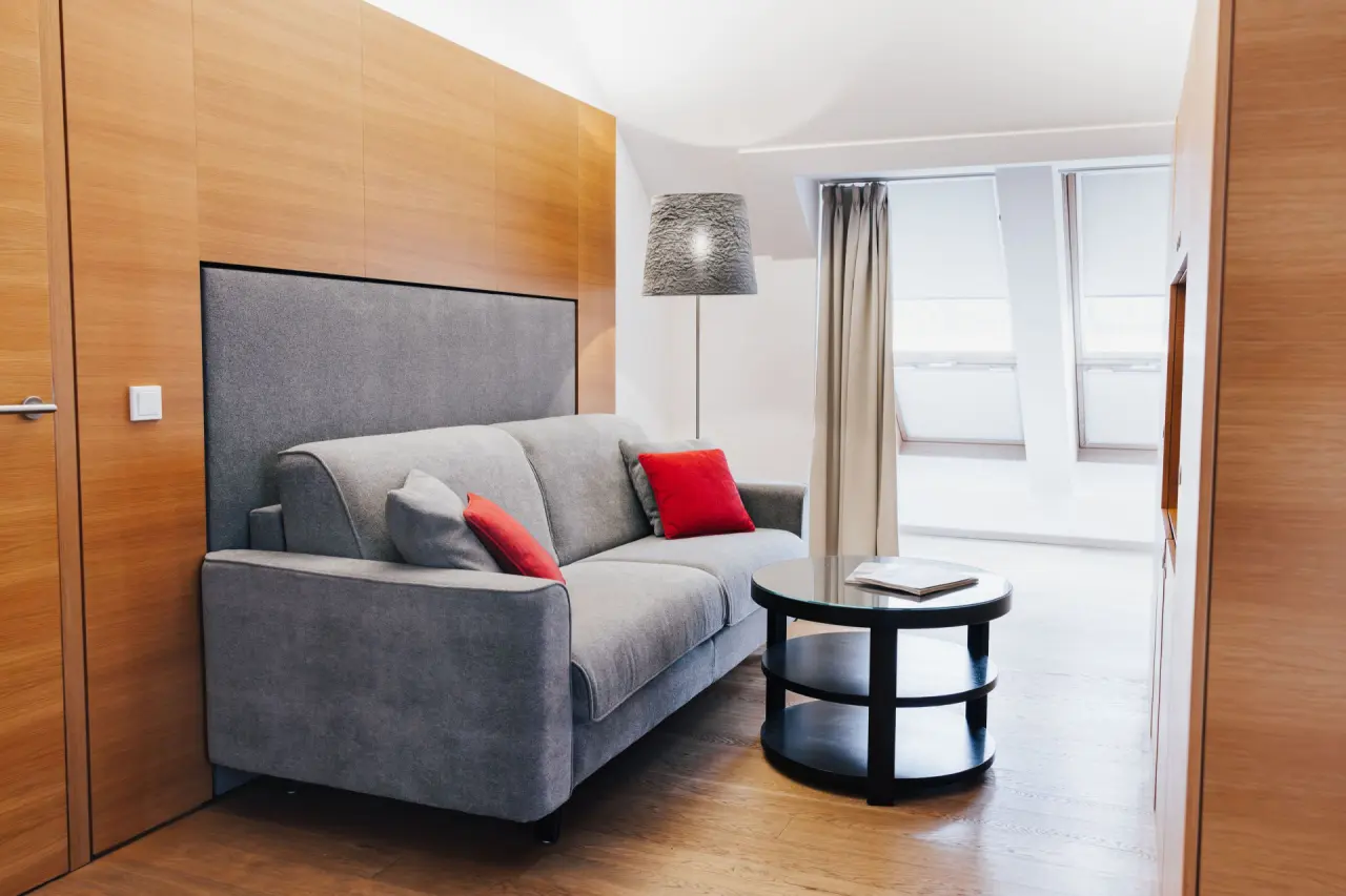 Gemütlicher Wohnbereich einer Suite mit Sofa und Holzelementen im Steigenberger Hotel and Spa Krems.