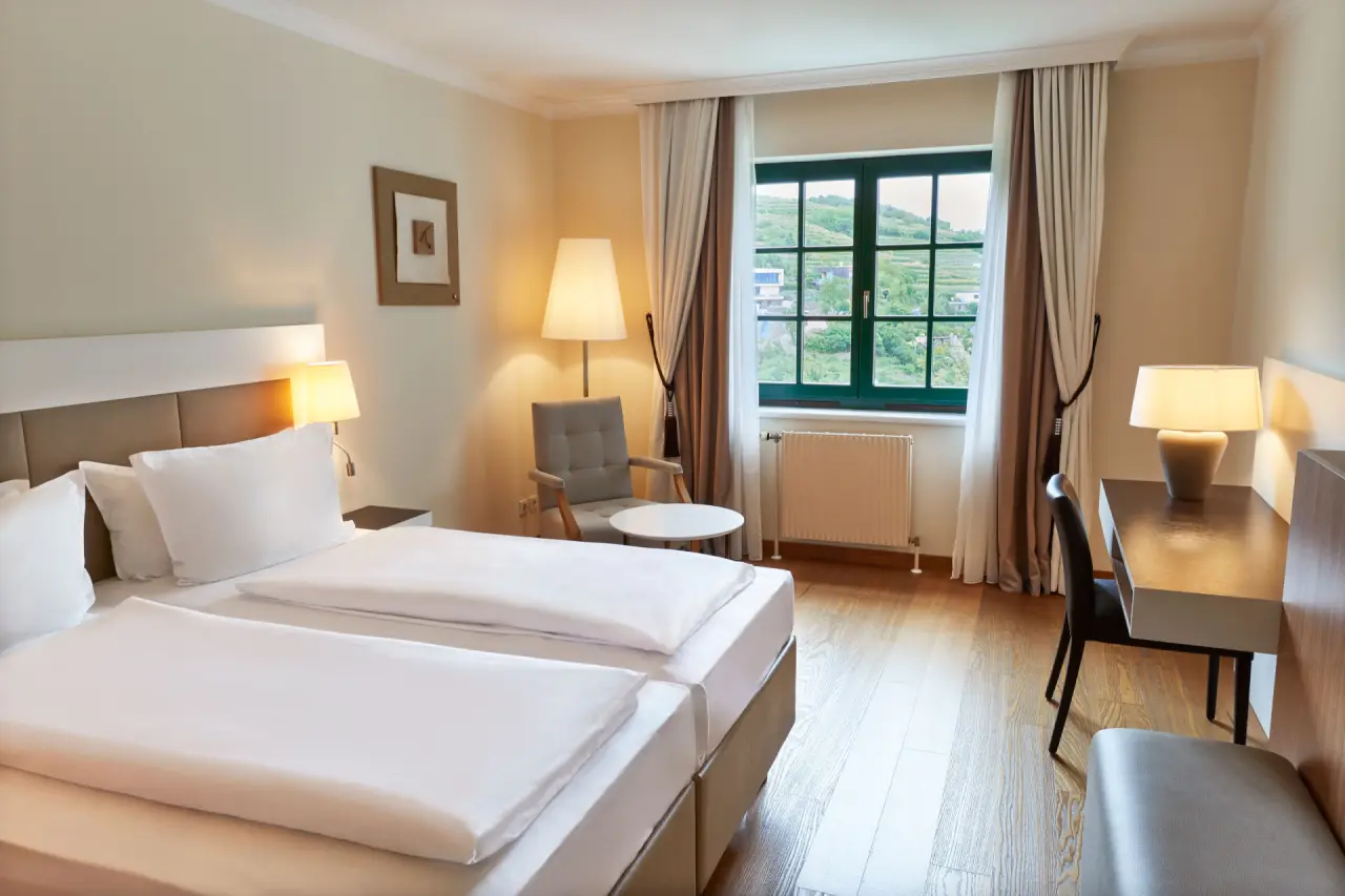 Komfortables Doppelzimmer mit Blick auf die Weinberge im Steigenberger Hotel and Spa Krems.