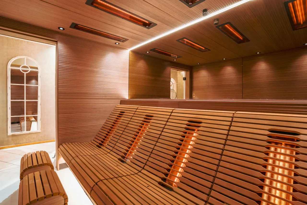 Moderne Infrarotkabine mit ergonomischen Holzbänken und warmem Licht im Wellnessbereich des Hotel Helvetia.
