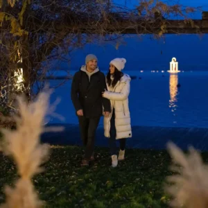 Paar bei romantischem Abendspaziergang am Ufer des Wolfgangsees mit stimmungsvoller Beleuchtung im Hotel Seevilla.