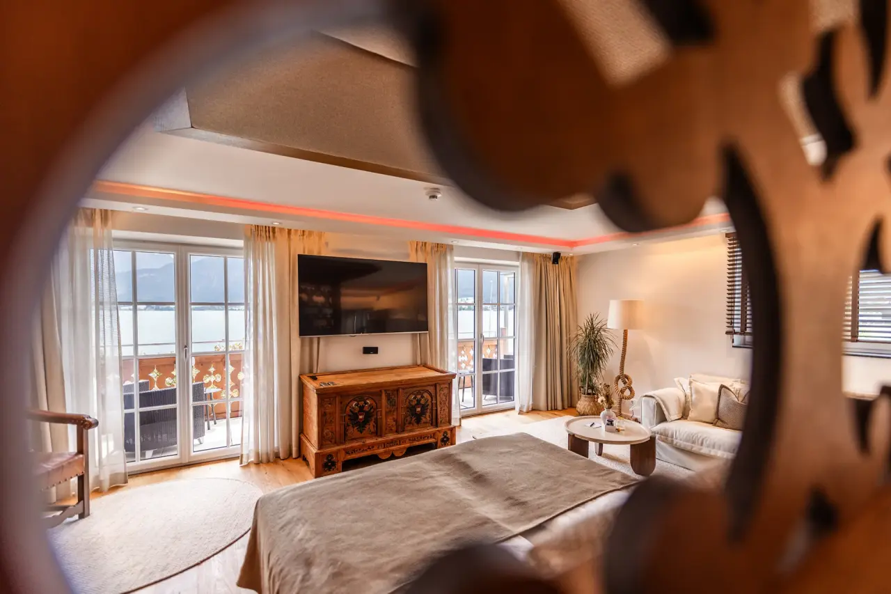 Gemütliches Hotelzimmer mit Seeblick und Balkon im Hotel Seevilla Wolfgangsee. Elegante Einrichtung und Alpenpanorama.