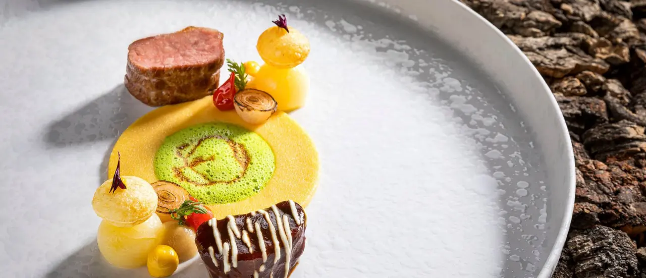 Exquisit angerichteter Hauptgang mit Fleisch und Gemüse auf einem Teller im Restaurant des Hotel Alpenhof.