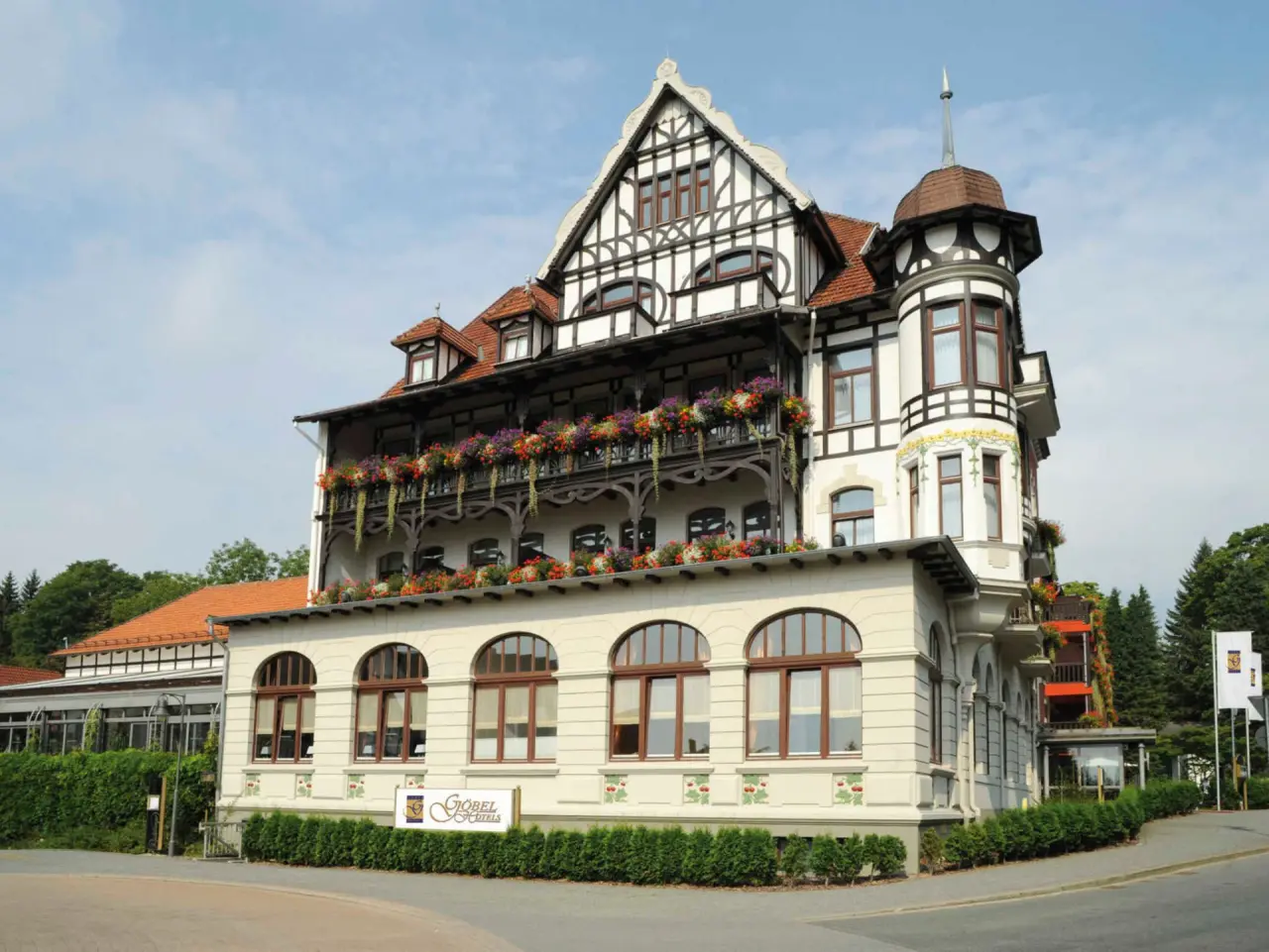 Aussenansicht des traditionellen Göbel's Vital Hotel mit Fachwerkfassade und Blumenkästen unter blauem Himmel.