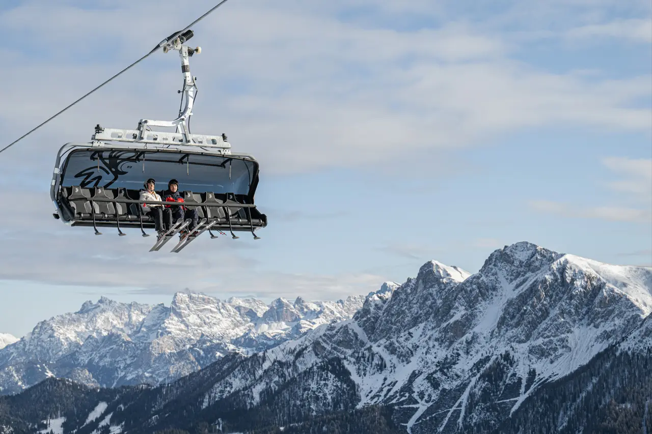 Mirabell Dolomites Hotel in Olang – Skifahrer im Sessellift vor Bergpanorama | Wellnesshotel Südtirol