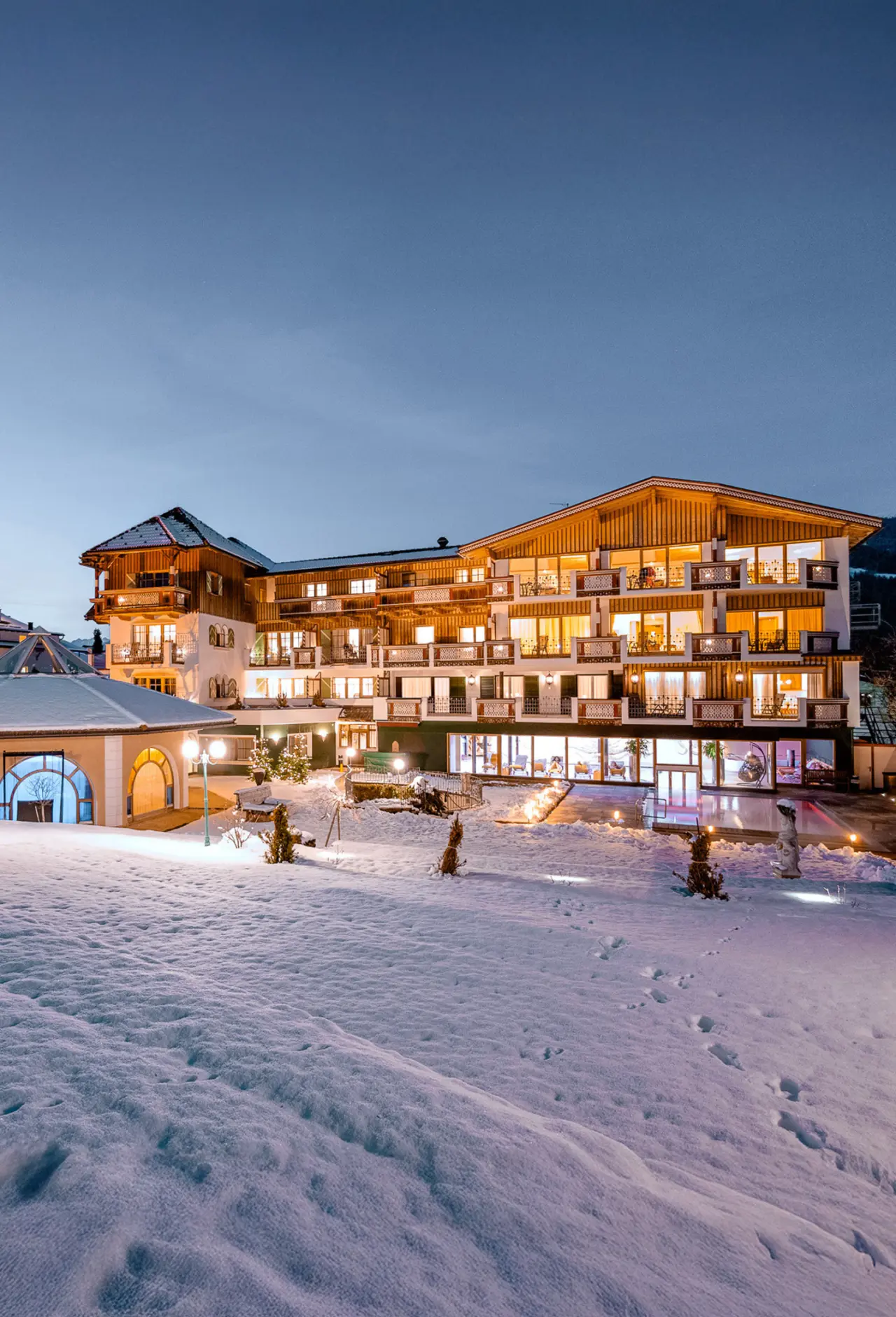 Mirabell Dolomites Hotel in Olang – Beleuchtete Außenansicht im Winter mit Schnee | Wellnesshotel Südtirol