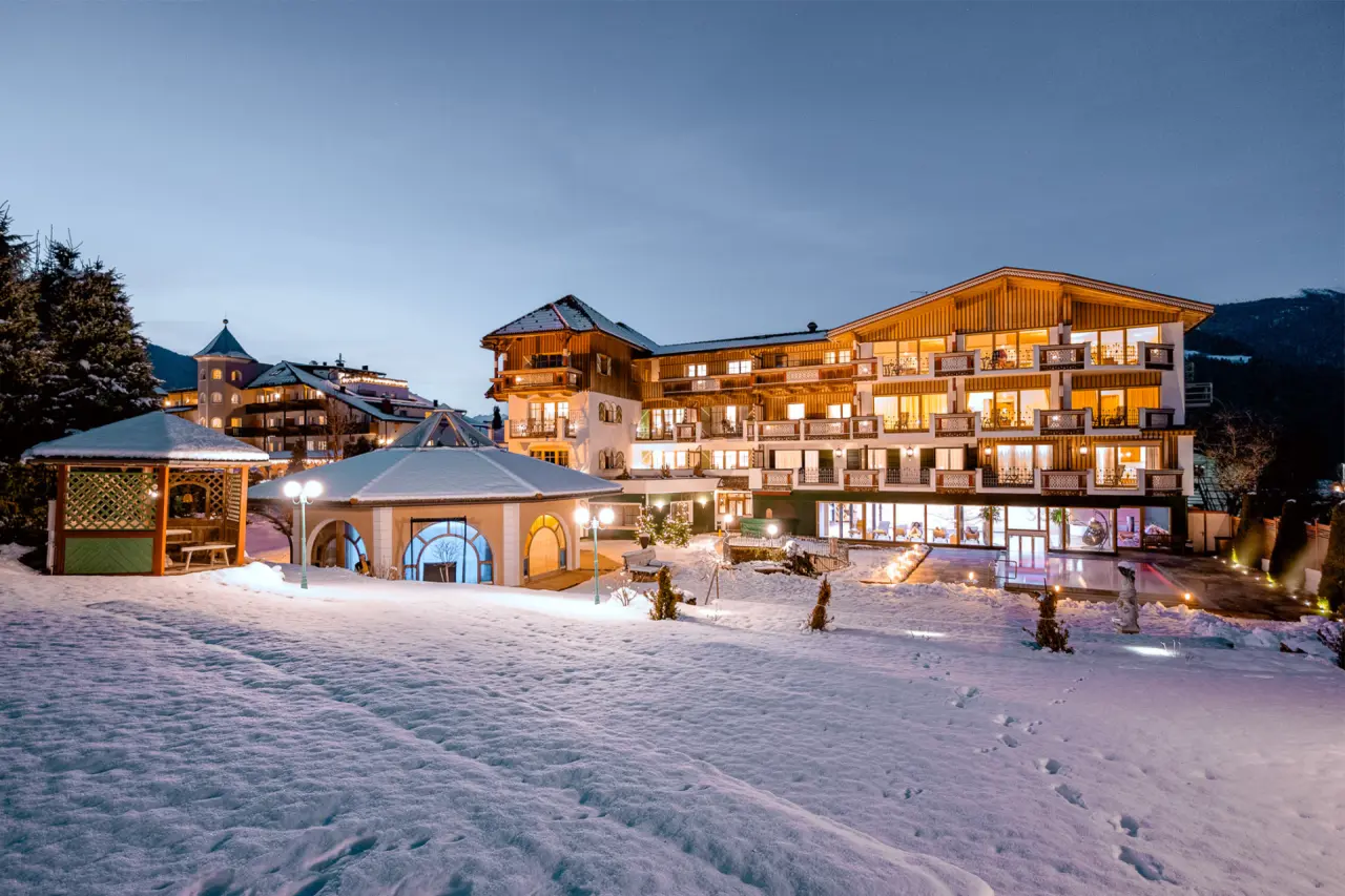 Mirabell Dolomites Hotel in Olang – Beleuchtete Außenansicht im Schnee bei Dämmerung | Wellnesshotel Südtirol