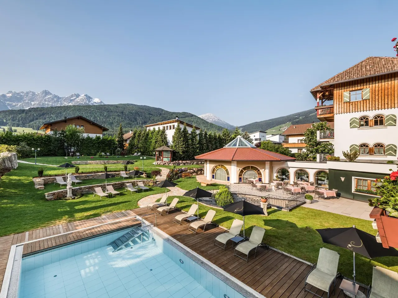 Mirabell Dolomites Hotel in Olang – Außenpool mit Liegewiese und Bergblick | Wellnesshotel Südtirol