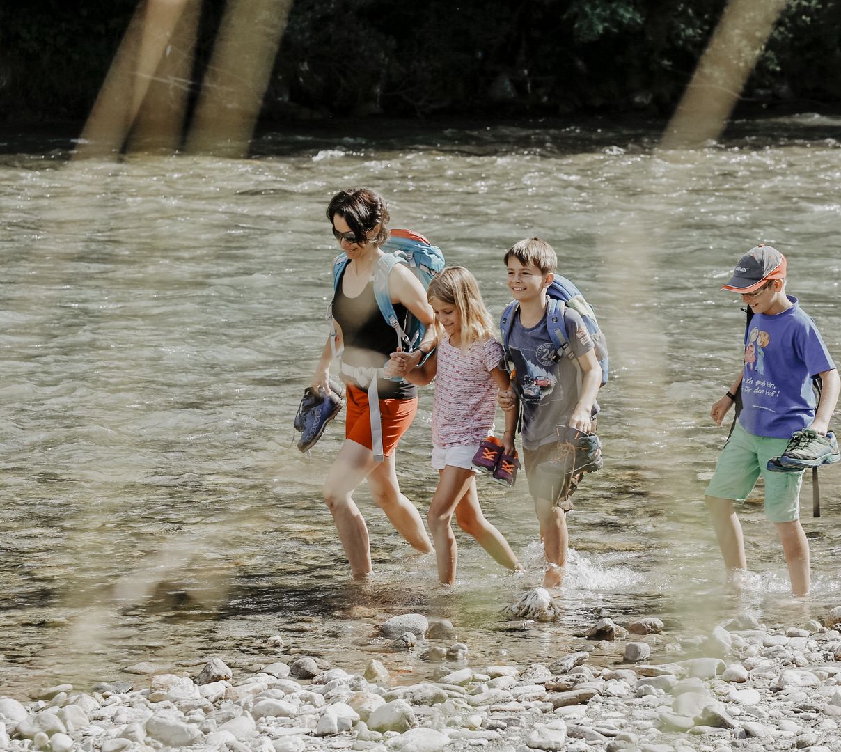 Hotel Schütterhof in Schladming – Familie beim Waten durch einen Fluss | Wellnesshotel Steiermark