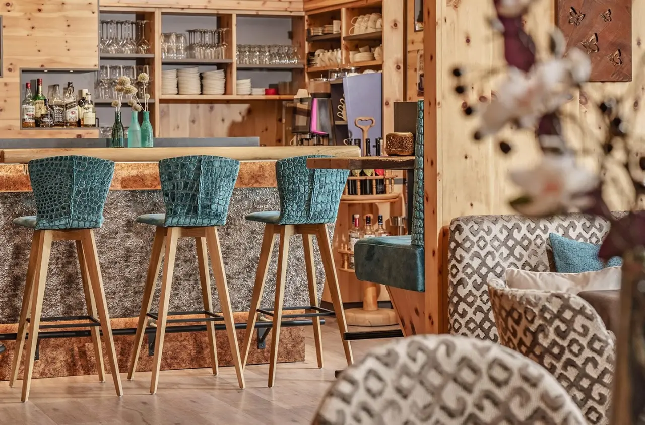 Gemütliche Hotelbar mit Holzvertäfelung und blauen Barhockern im Hotel Waldfrieden.