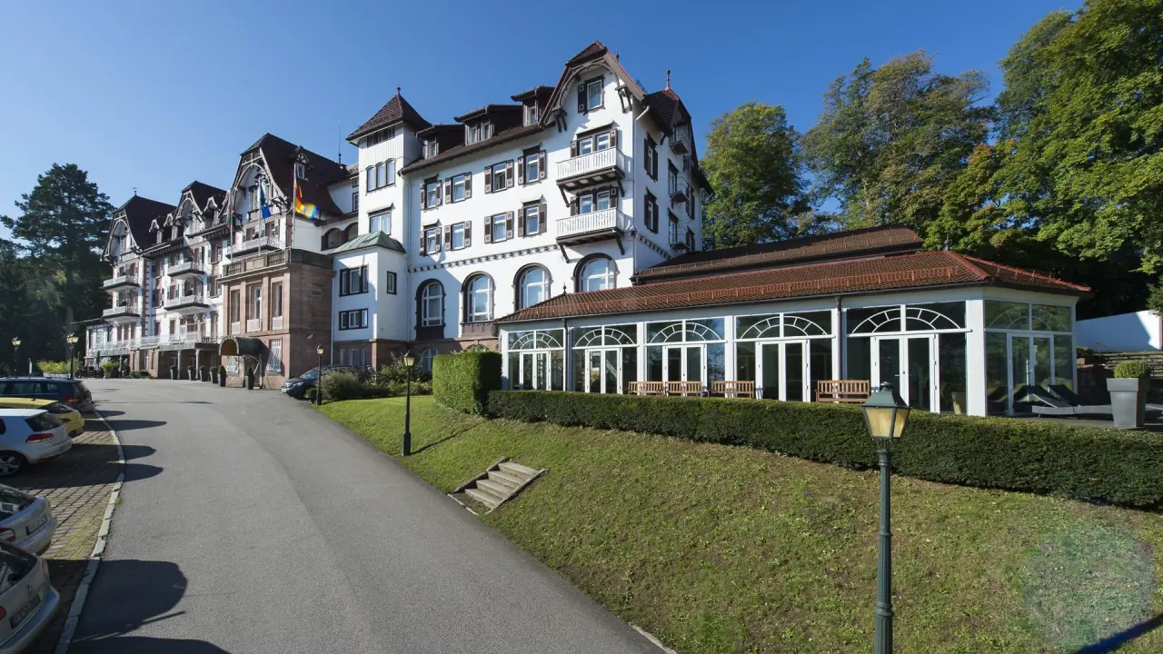 Aussenansicht des historischen Wellnesshotel Palmenwald mit elegantem Gebäude und sonnigem Gartenbereich.