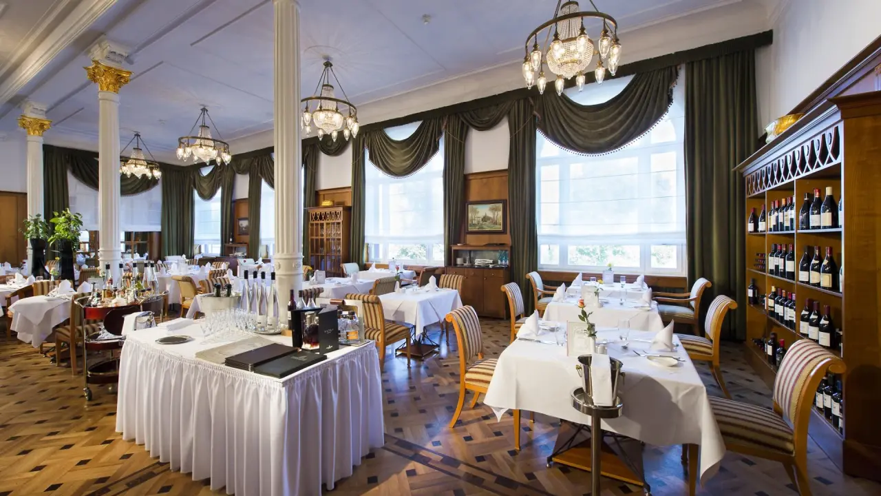 Elegantes Restaurant im Wellnesshotel Palmenwald mit festlich gedeckten Tischen und Weinauswahl.
