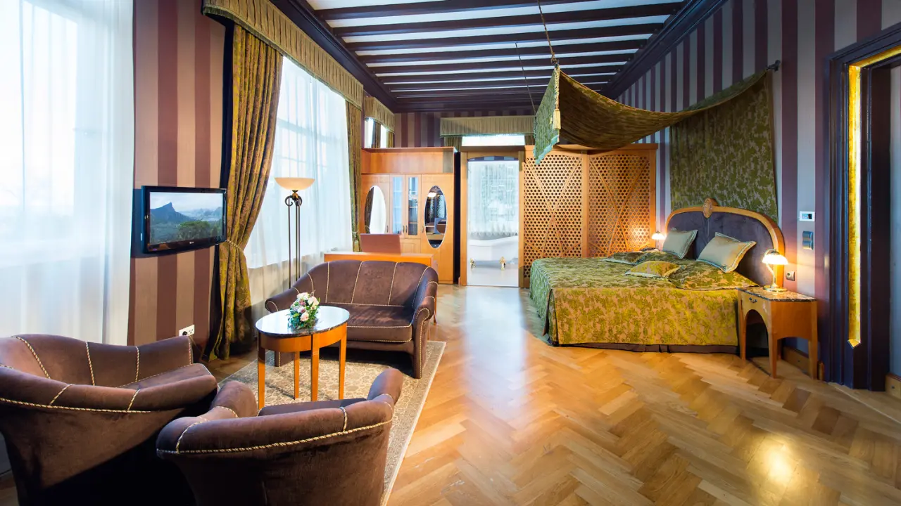 Elegantes Doppelzimmer mit Sitzbereich und freistehender Badewanne im Wellnesshotel Palmenwald.