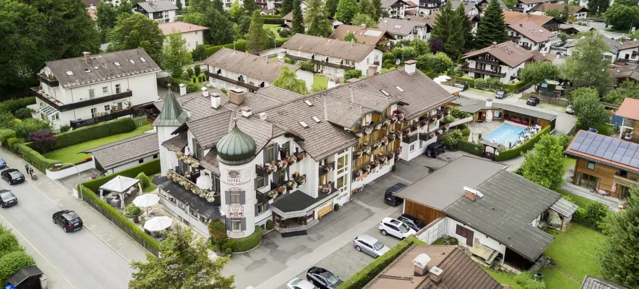 Luftaufnahme des traditionellen Hotel Staudacherhof mit Aussenpool und Gartenanlage in Garmisch-Partenkirchen.