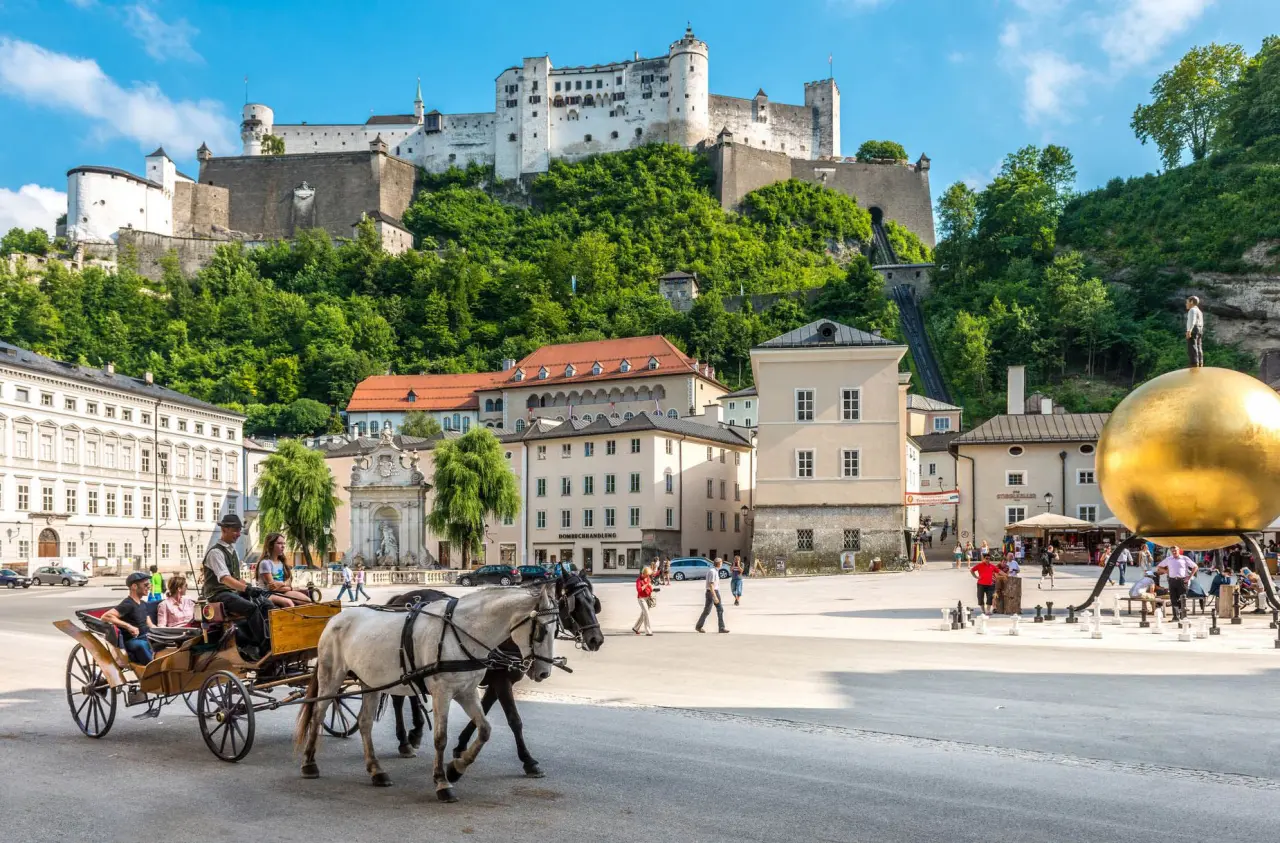 Historische Festung Hohensalzburg und Kapitelplatz in Salzburg mit Pferdekutsche. Umgebung des Romantik Spa Hotel Elixhauser Wirt.