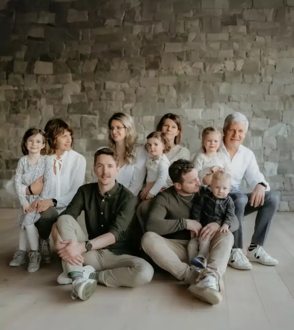 Familienportrait mit mehreren Generationen vor einer modernen Steinwand im Sport- und Wellnesshotel Held****s.