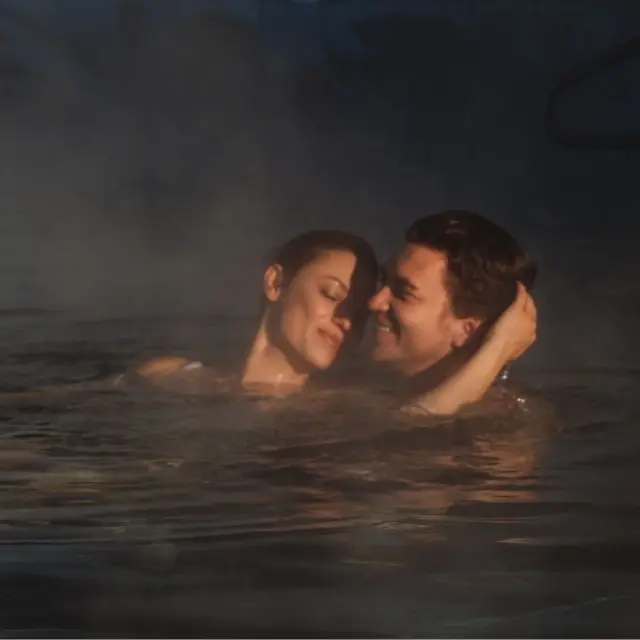 Romantisches Paar entspannt im warmen Aussenpool mit Dampf im Sport- und Wellnesshotel Held****s.