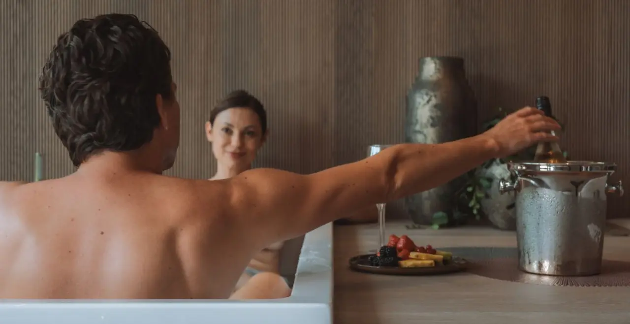 Paar entspannt im Whirlpool mit Sekt und frischen Früchten im Sport- und Wellnesshotel Held****s