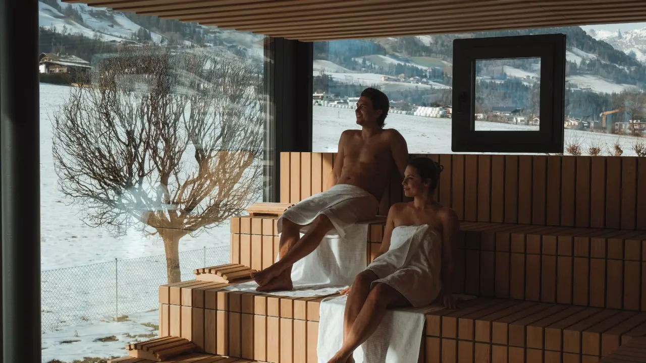 Panorama-Sauna mit Bergblick und entspannenden Gästen im Sport- und Wellnesshotel Held****s.