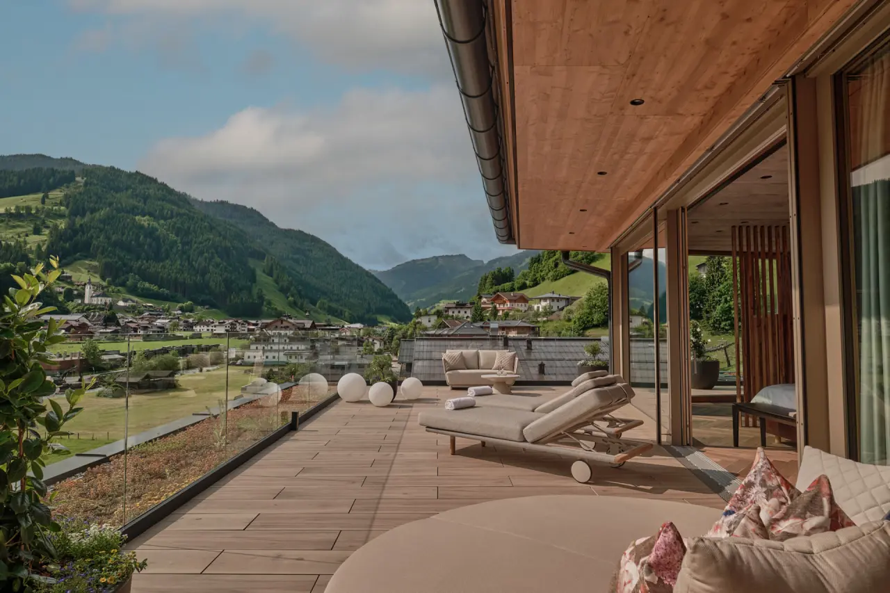 Geräumige Suite-Terrasse mit Lounge-Möbeln und Alpenblick im DAS EDELWEISS Salzburg Mountain Resort.