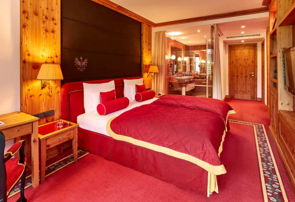 Luxuriöses Doppelzimmer im alpinen Stil mit offenem Bad im Kempinski Hotel Das Tirol.