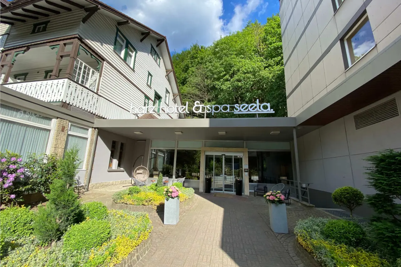 Haupteingang des Harz Hotel & Spa Seela mit gepflegtem Garten, traditioneller und moderner Architektur.
