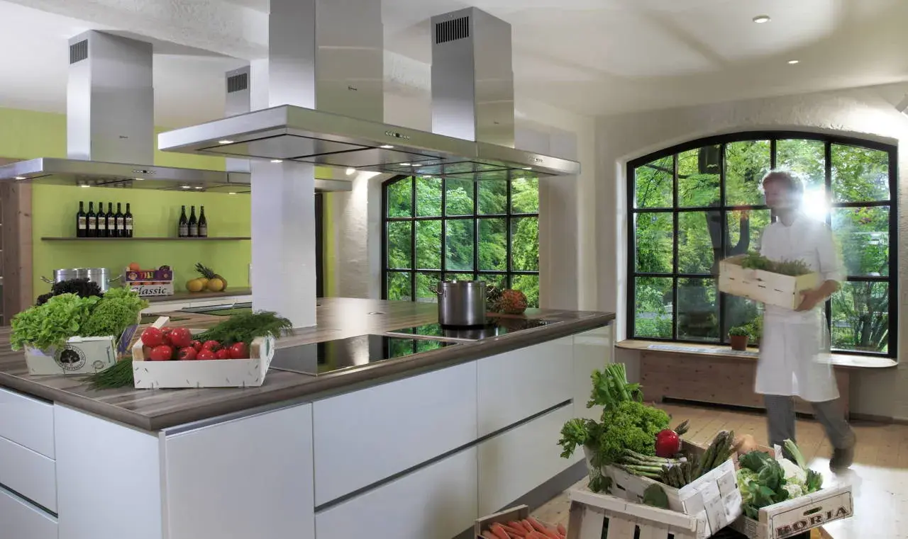 Moderne Hotelküche im Waldhaus Ohlenbach mit frischen Zutaten und Blick ins Grüne.